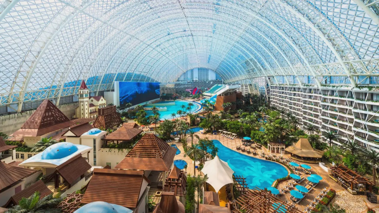 The Global Center indoor waterpark in Chengdu — a wave pool, sand beach and slides under an enormous glass roof.