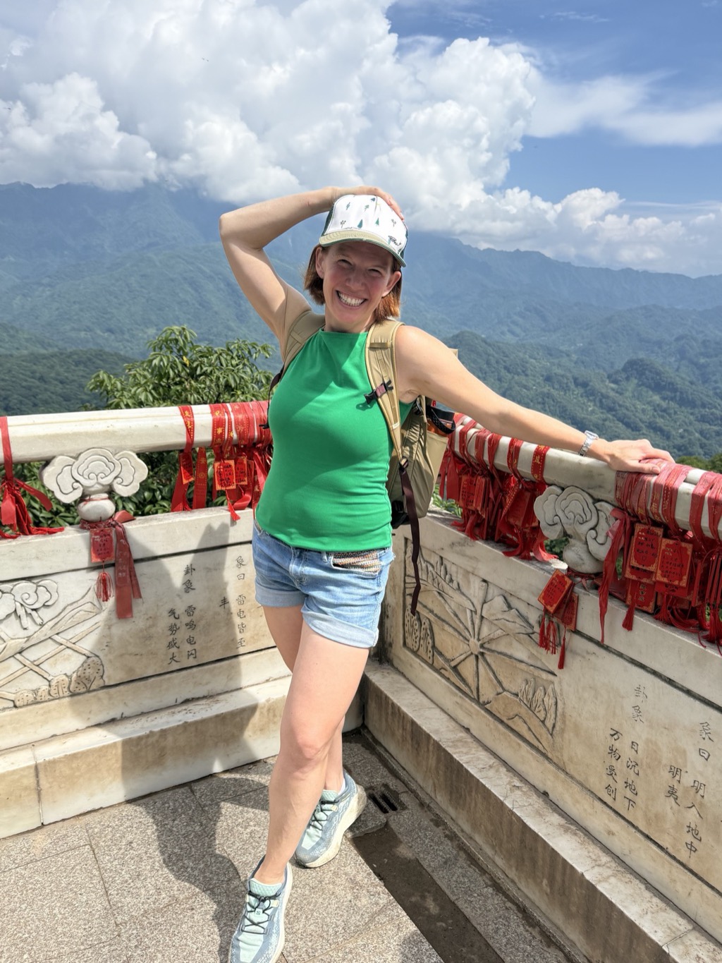 Danielle at a mountain viewpoint on Mount Qingcheng lined with red prayer ribbons.