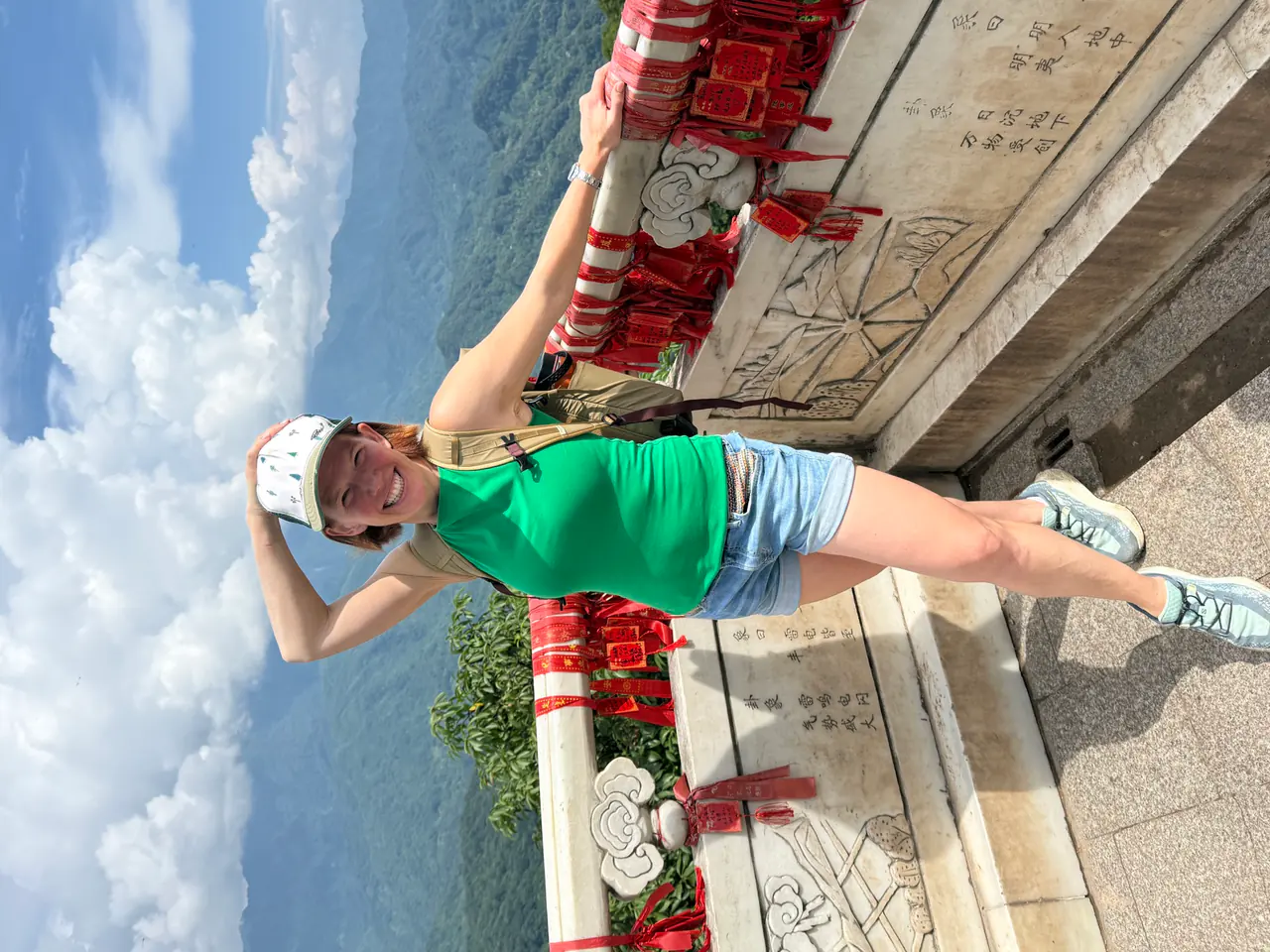 Danielle at a mountain viewpoint on Mount Qingcheng lined with red prayer ribbons.