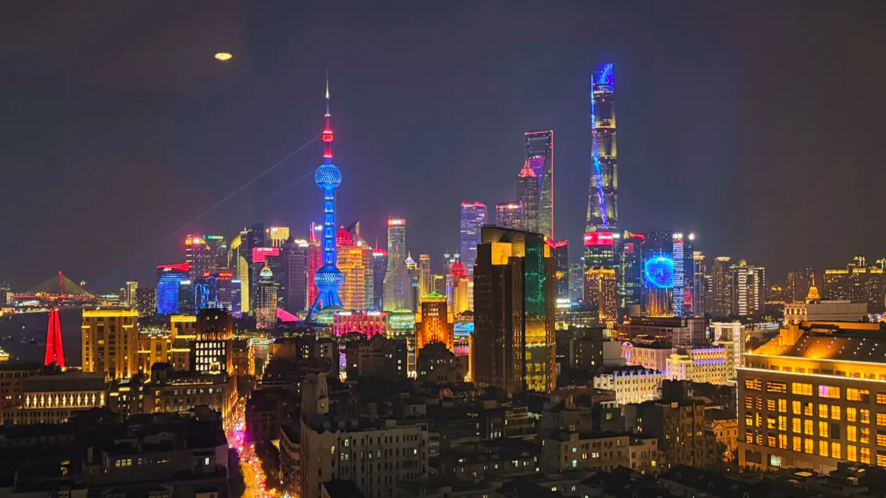 The illuminated Pudong skyline of Shanghai at night, seen across the Huangpu River.