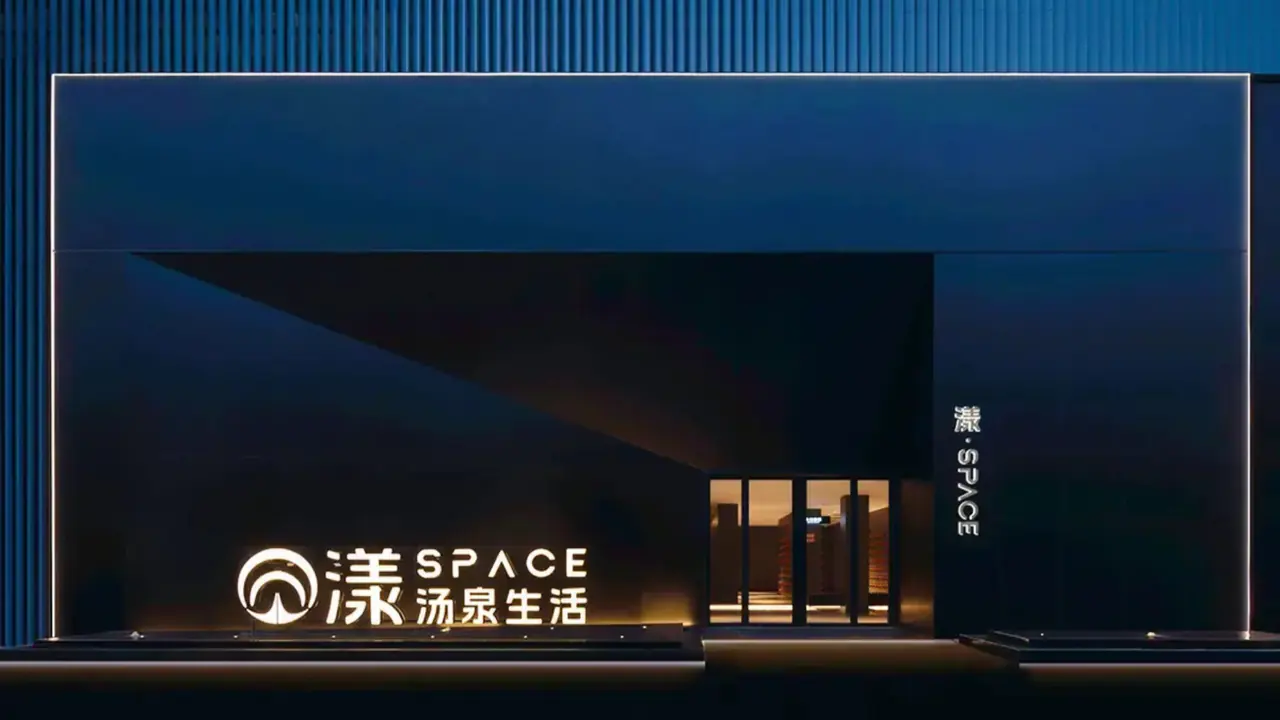The lit entrance and signage of the SPACE 24-hour hot-spring spa in Shanghai at night.